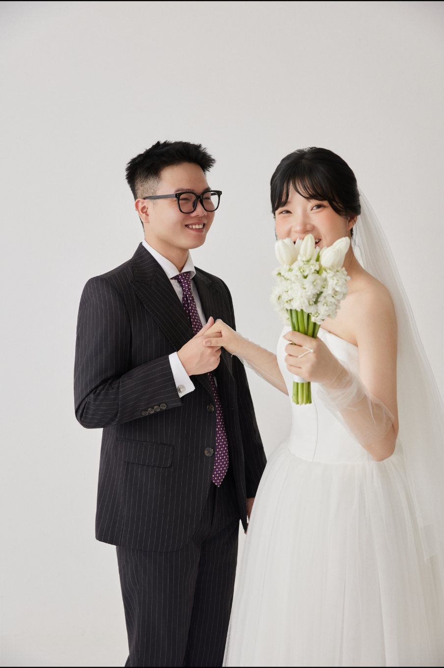Cô dâu chú rể cười rạng rỡ bên hoa cưới