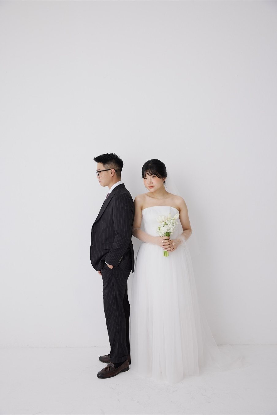 Cô dâu chú rể đứng tựa lưng nhau