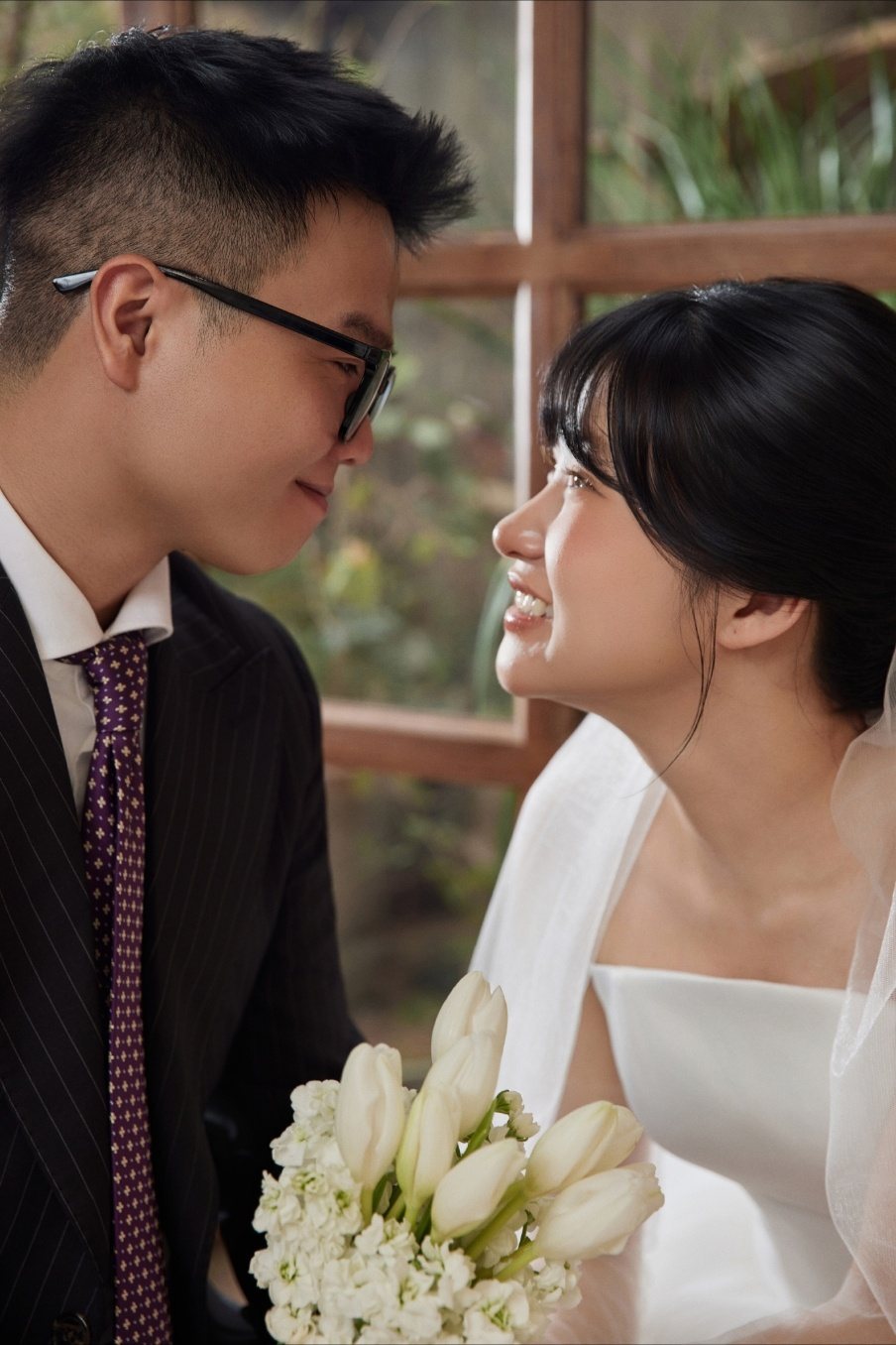 Cô dâu chú rể bên khung cửa sổ